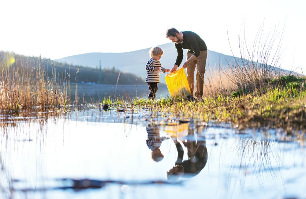 Boy with Dad mountain picking up trash 1000x650 150 dpi AdobeStock_373514849